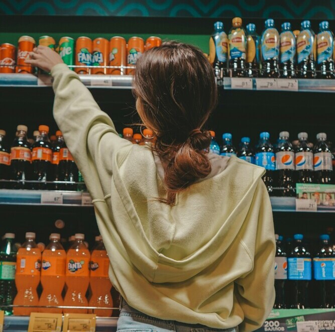 woman reaching to a supermarket shelf