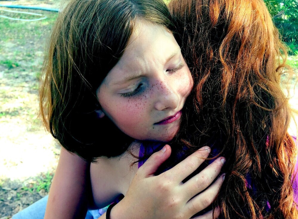 2 young girls hugging each other 