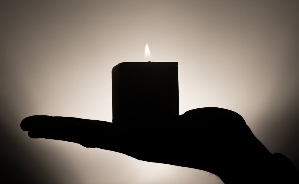 a hand holding a candle 