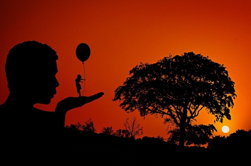 silhouette of a man blowing another silhouette person off his hand to represent the power of forgiveness