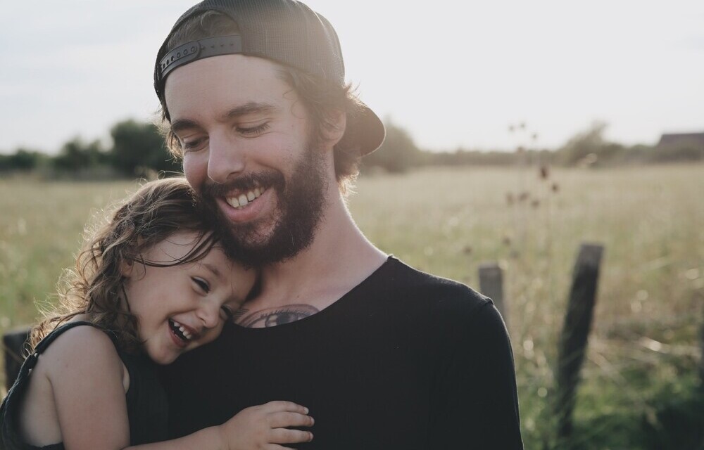 Man holding his daughter and smiling